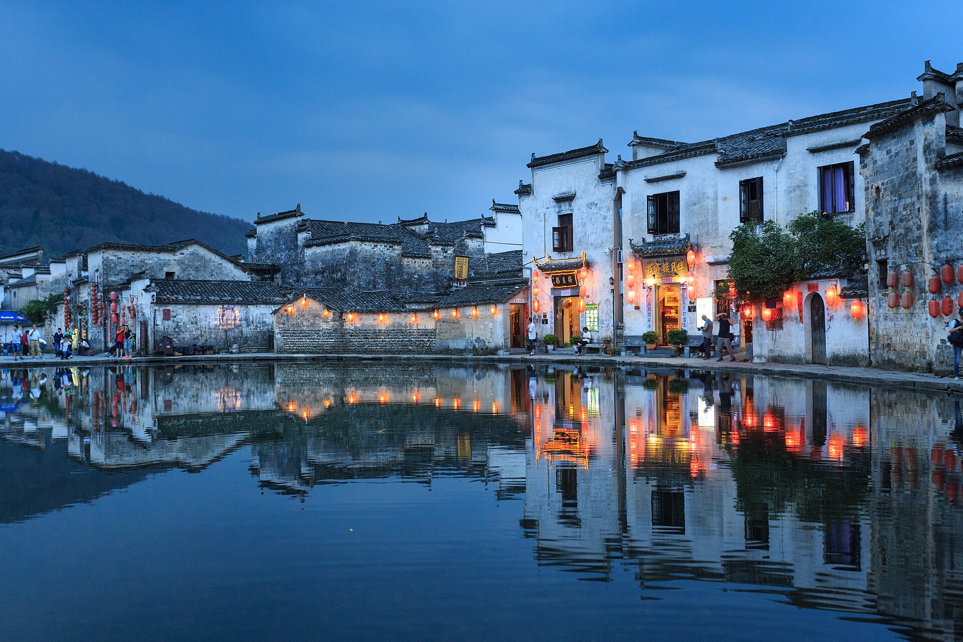 暮色中的宏村，白墙黛瓦倒映在水中
